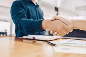 Handshake symbolizing successful mediation with signed documents in Fort Bend County.
