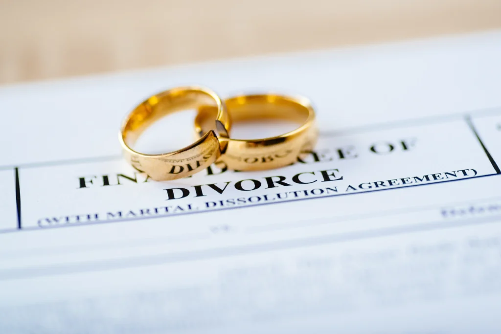 divorce decree paperwork with wedding rings