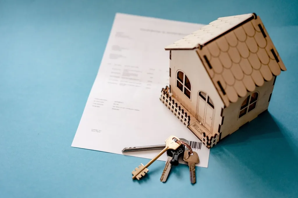 Miniature house and keys placed on top of a document, symbolizing property division and ownership issues during a Texas divorce.