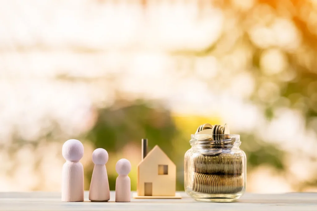 Wooden family figures, a small house, and a jar of coins symbolizing asset division in a high-net-worth divorce in Houston.