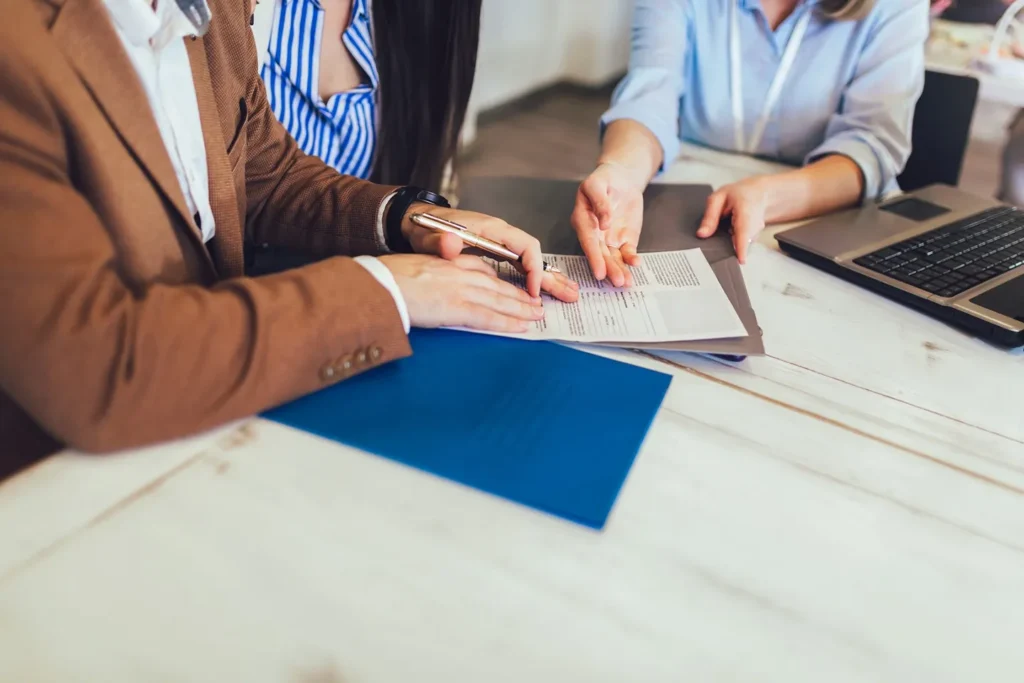 Couple sitting at a desk reviewing legal documents with a professional, suggesting a family law consultation in Stafford.
