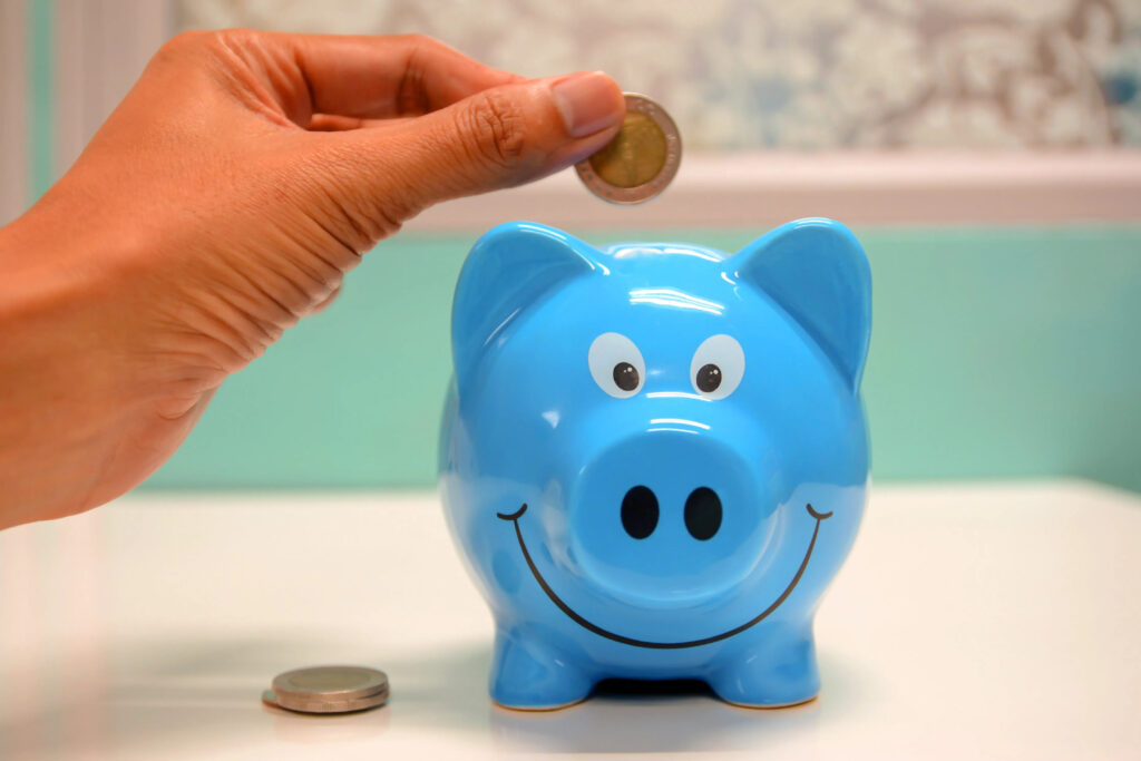 hand putting money in piggy bank for child support